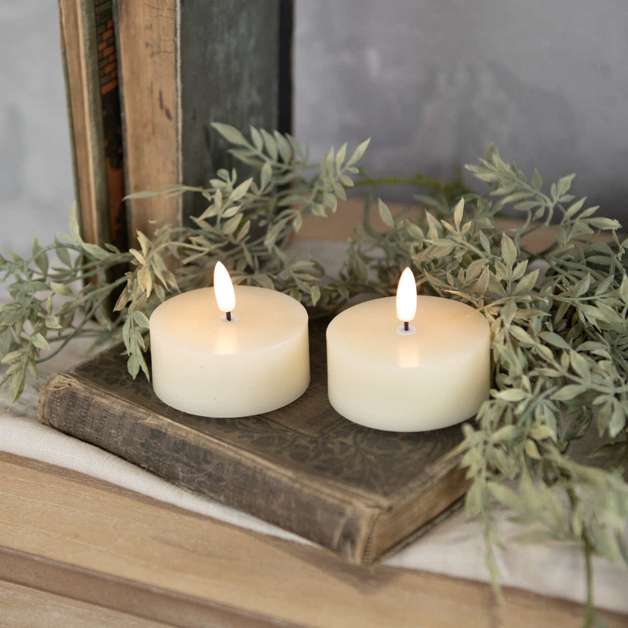 Set of three cream tealight candles with oversized 3D flame designs on plastic holders.
