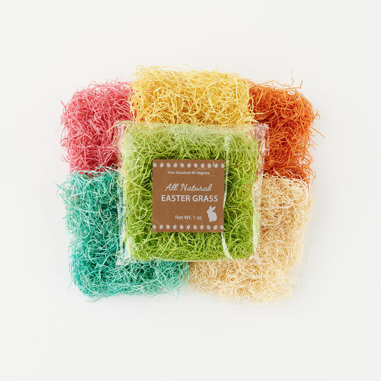 A pack of green natural fiber Easter grass in front of pink, yellow, orange, teal, and tan bundles.