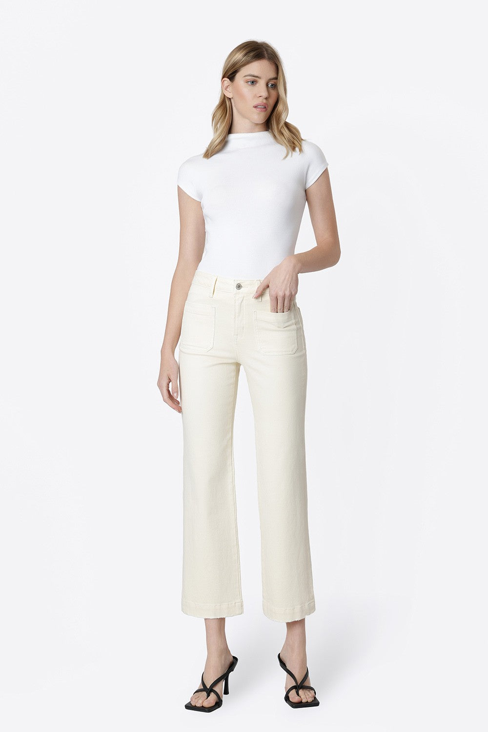 Model wearing Ailleah high-rise slim wide leg jeans in natural color with patch pockets.