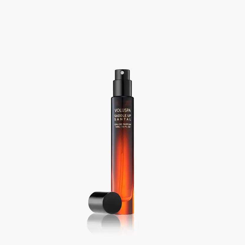 A small glass bottle of Saddle Up Santal Eau De Parfum with a black cap and clear liquid.