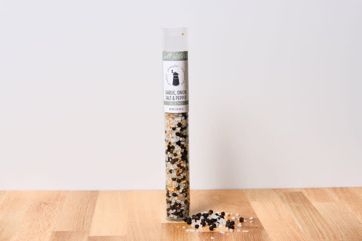 Glass jar containing a salt blend with visible flecks of black pepper.