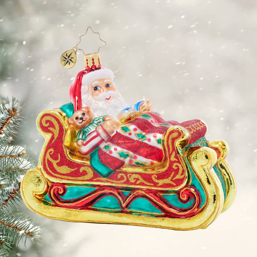 Ceramic Santa figurine in a sleigh sleeping peacefully with red suit and white beard.