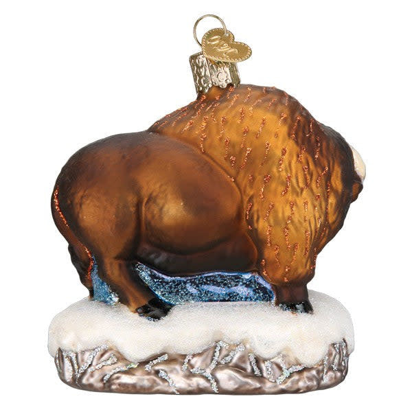 Glass ornament featuring a Santa Claus figure riding a bison with silver interior detailing.