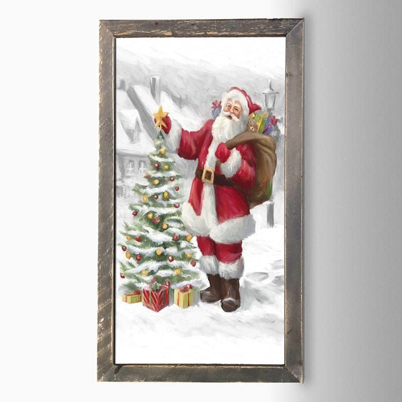 Natural wood frame holding a matte print of Santa standing beside an outdoor tree.