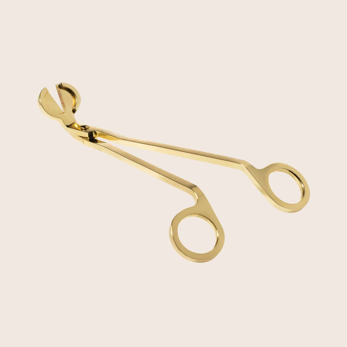 Gilded Wick Trimmers in gold metal with a sleek curved handle.