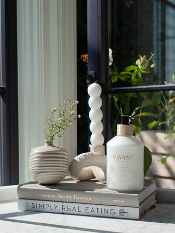 Hand Lotion in Fresh Linen scent inside a durable glass bottle with a recyclable brushed gold pump.