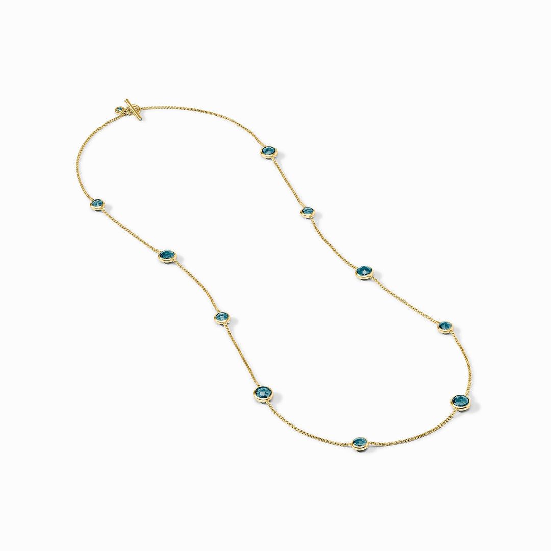 Rainbow Station Necklace in 24K gold plate with blue glass stones and a toggle closure.