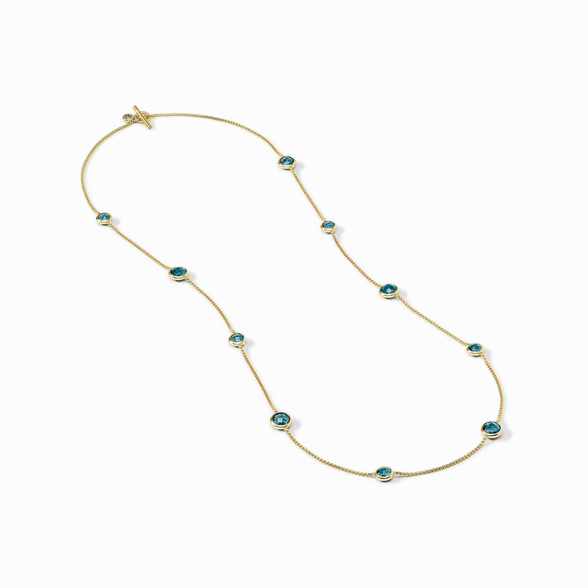 Rainbow Station Necklace in 24K gold plate with blue glass stones and a toggle closure.