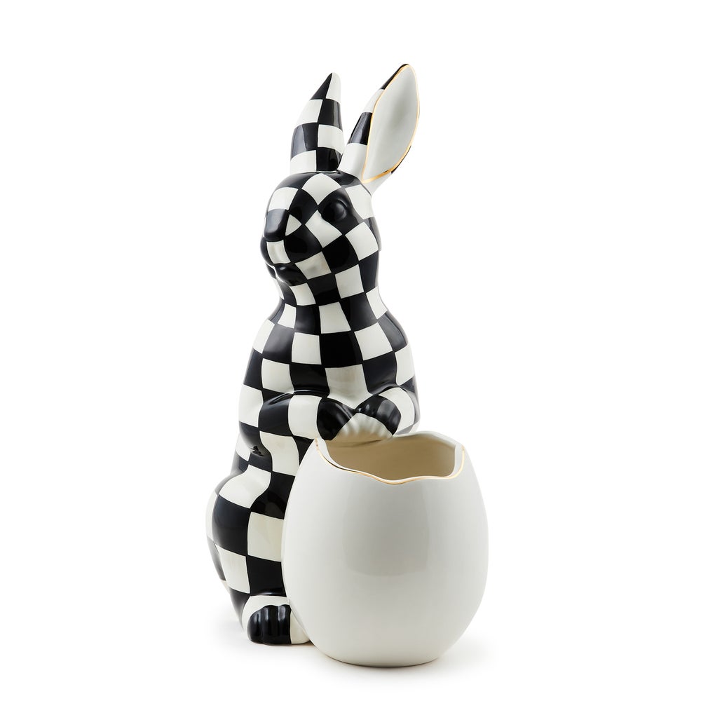 Large black and white checkered ceramic rabbit figurine standing next to a white egg-shaped vase.