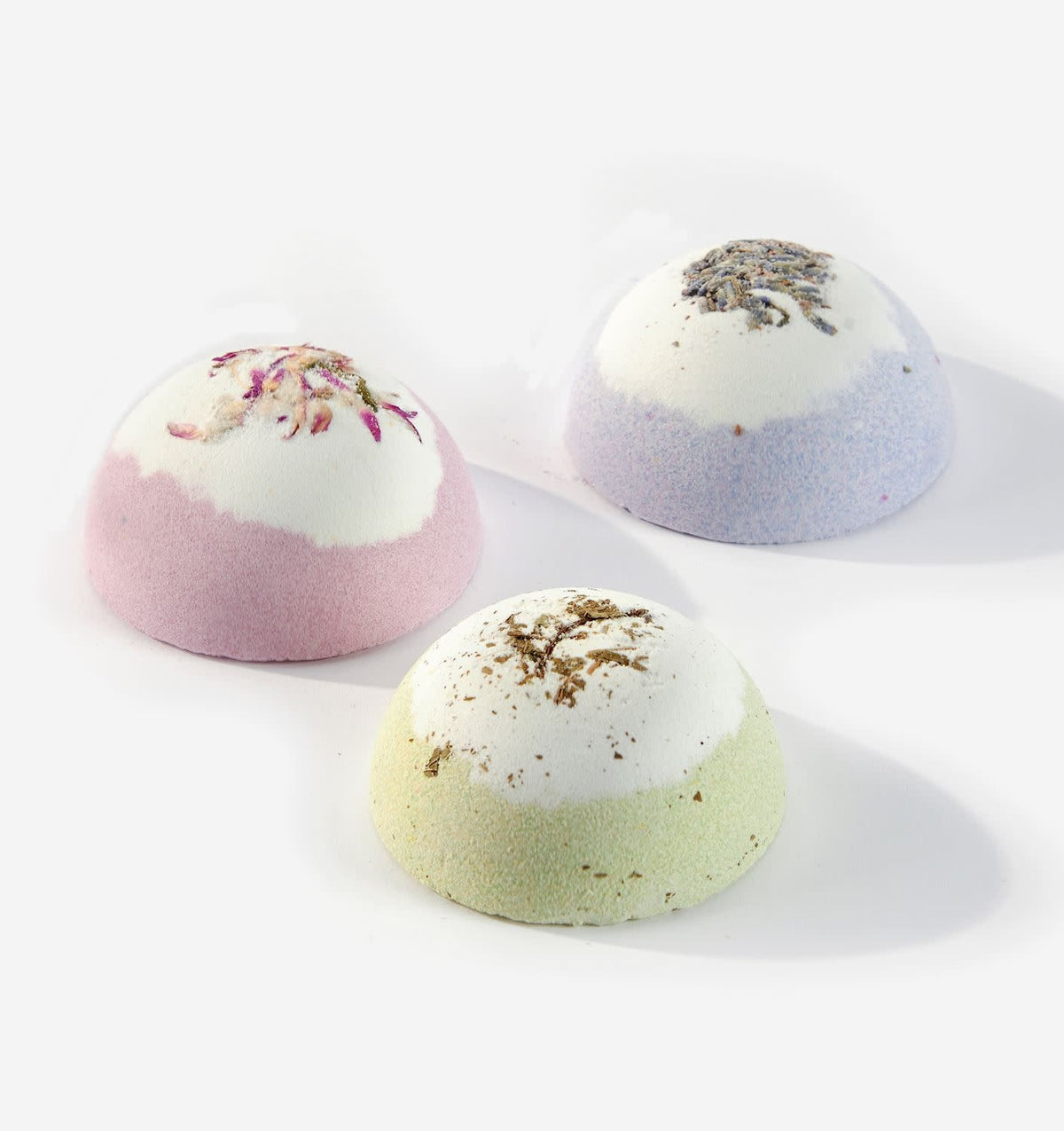 A round Garden Joy scented bath fizzer in pastel green with a subtle floral pattern.