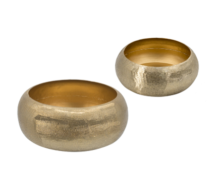 Gold suede aluminum vase with a rounded industrial silhouette on a tabletop.