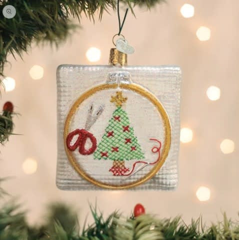 Christmas cross stitch ornament featuring a festive red and green holiday pattern on white fabric.