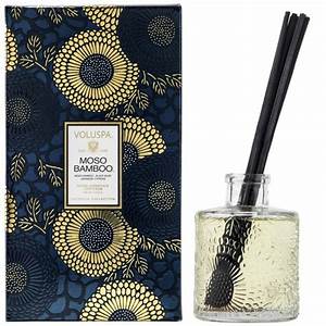 Reed diffuser bottle with clear glass body, neutral liquid, and dark reeds.