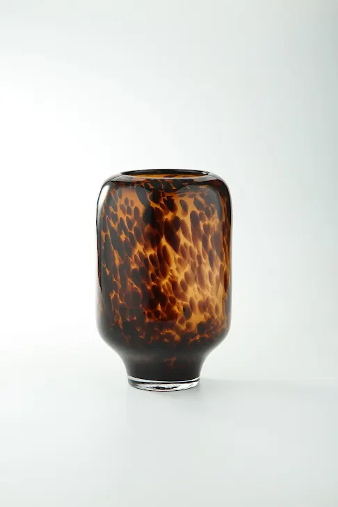 Leopard print glass vase with a cylindrical silhouette measuring approximately seven inches wide.