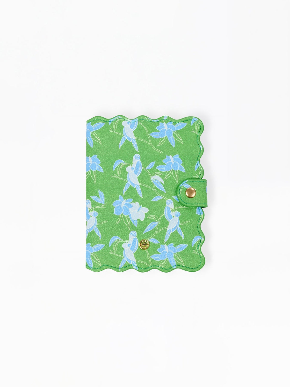 Green vegan leather passport cover with a blue tropical bird and flower print and scalloped edges.