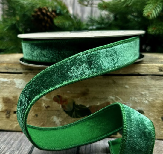 1 inch wide pine green velvet ribbon with matching dupion back on a wooden surface.