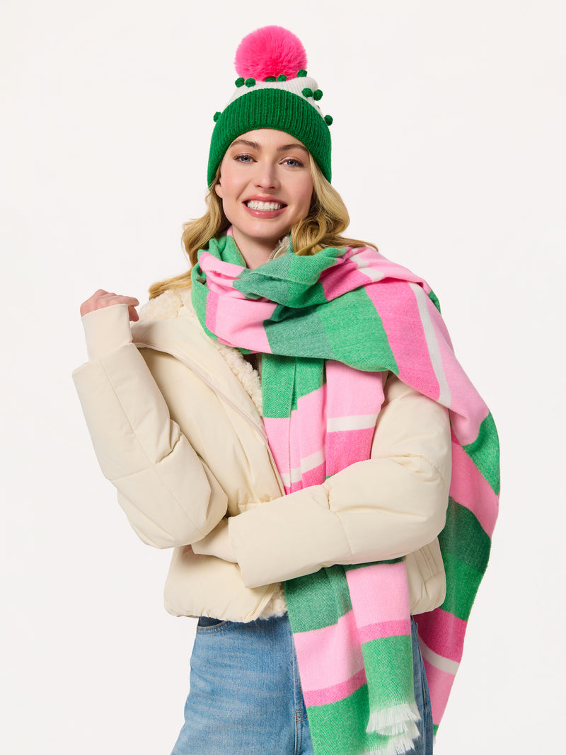 Woman wearing the Kayla Scarf, an oversized pink and green striped polyester scarf.