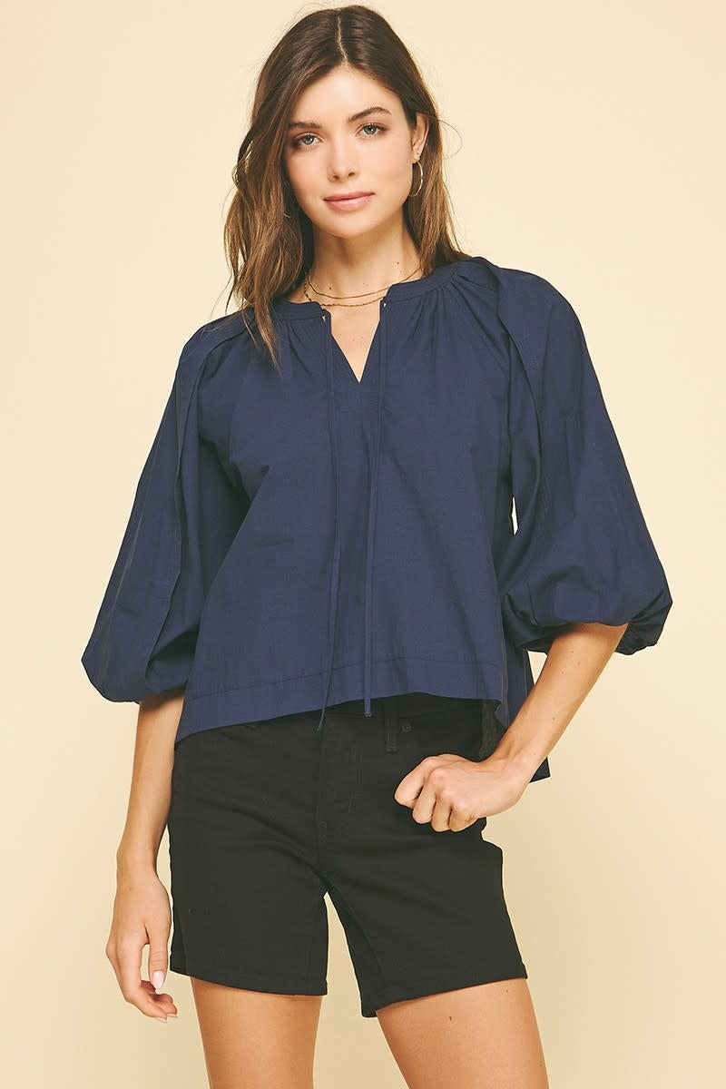Navy cotton self-tie V-neck blouse with balloon short sleeves.