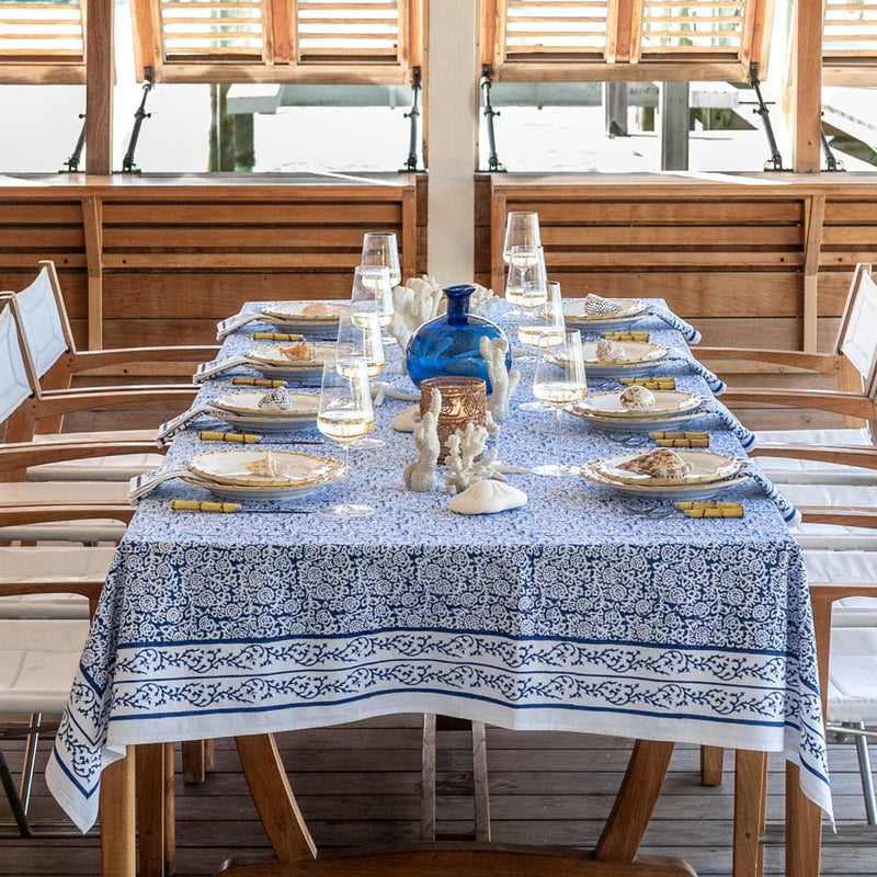 Tapestry Dark Blue Tablecloth with a floral pattern on a set dining table with ocean views.