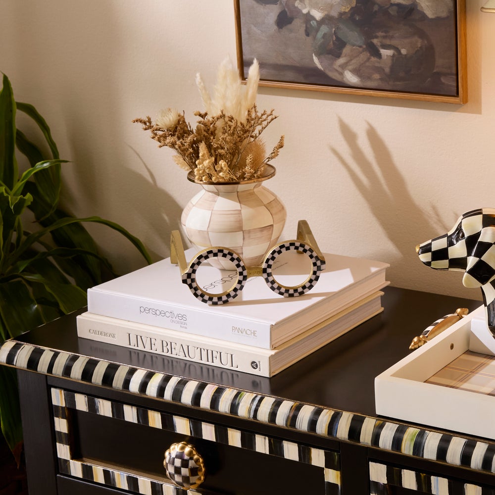 Round Eye Glasses Decor with black and white checkered frames on a stack of books.