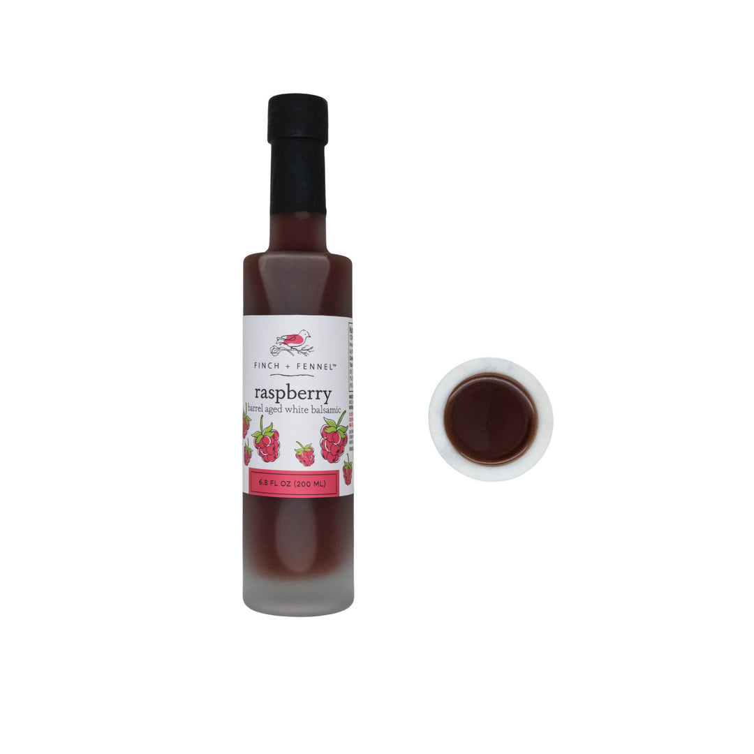 6.8 oz bottle of raspberry barrel aged white balsamic vinegar with a clear glass silhouette and red label.