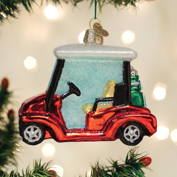 Red glass golf cart Christmas ornament with a white roof and green golf bag on the back.