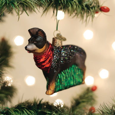 Glass Australian Cattle Dog ornament with a red bandana hanging on a Christmas tree.