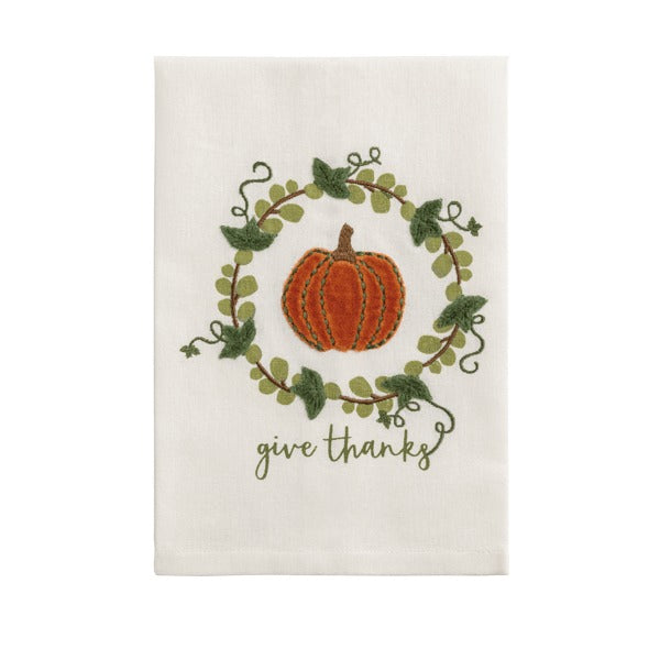 White velvet towel featuring an embroidered orange pumpkin inside a green leaf wreath.