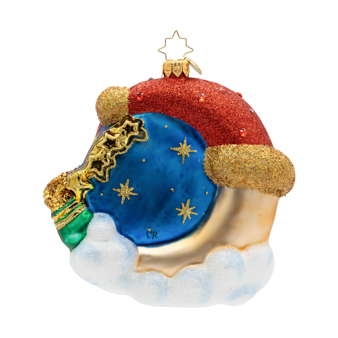 Crescent Wishes Santa glass ornament featuring a blue night sky, gold stars, and a red glitter hat.
