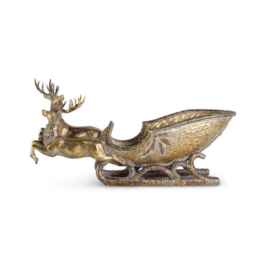 Antiqued gold resin sleigh with two deer pulling a 25-inch wide decorative piece.