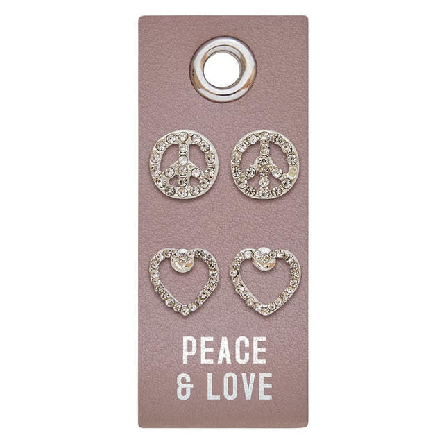 Silver stud earrings featuring a peace sign charm with rhinestone accents on PU leather.
