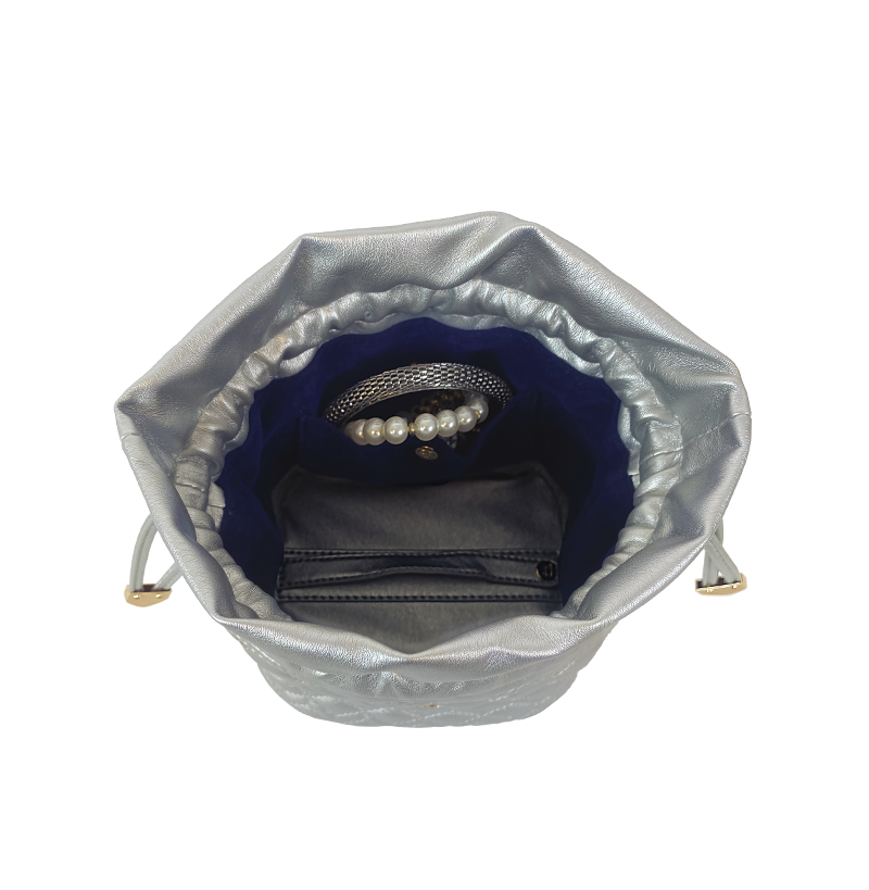 Open silver vegan leather jewelry case with suede interior holding ten clear removable pouches.