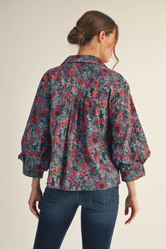Woman wearing Riley button-down floral top with collared neckline and three-quarter sleeves in small size.