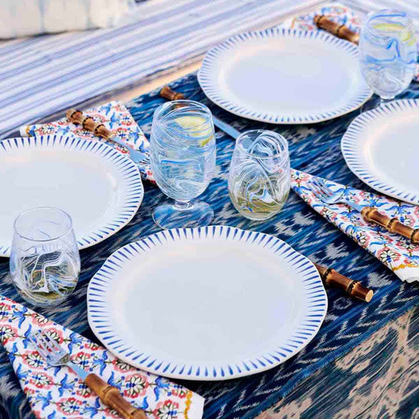 Delft blue ceramic dinner plate with white glaze and radiant stripe rim pattern