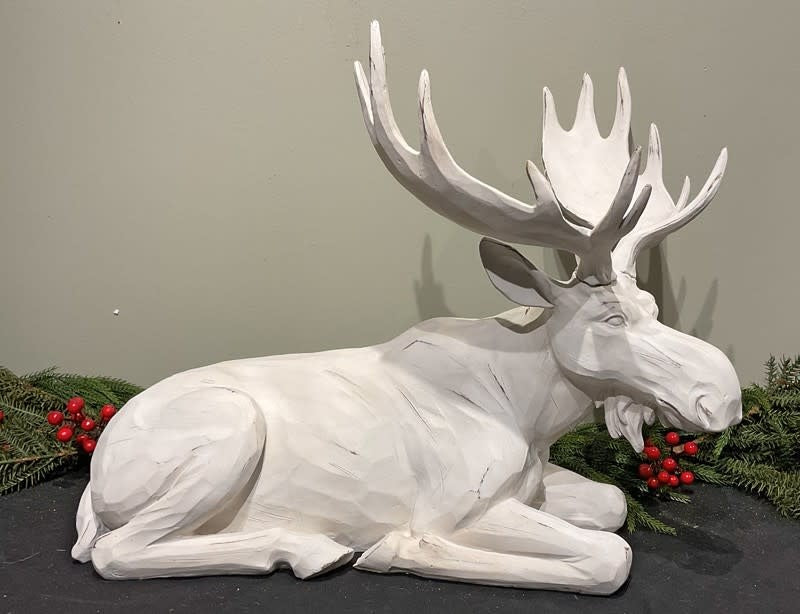 White ceramic sitting moose figurine with rustic lodge-style decor