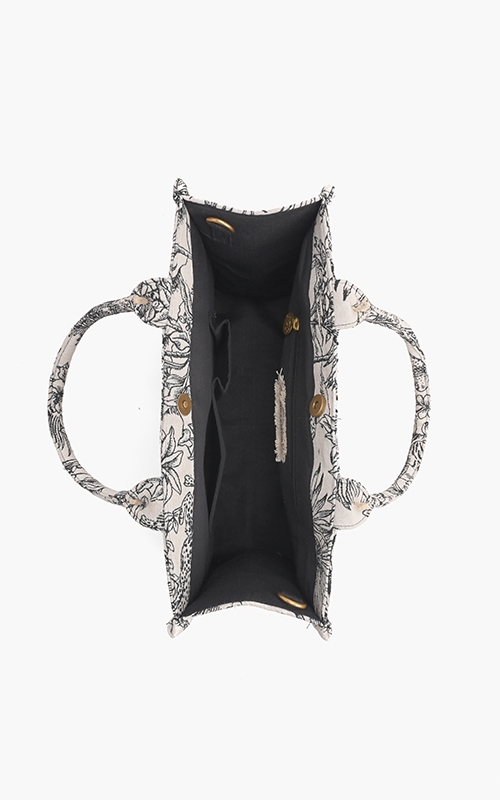 Top view of the Forbidden Tote showing black lined interior, zip pocket, and magnetic closure.