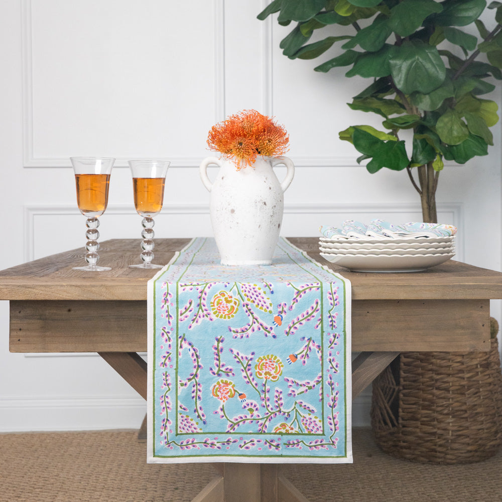 Sky blue cotton table runner with dahlia floral pattern.