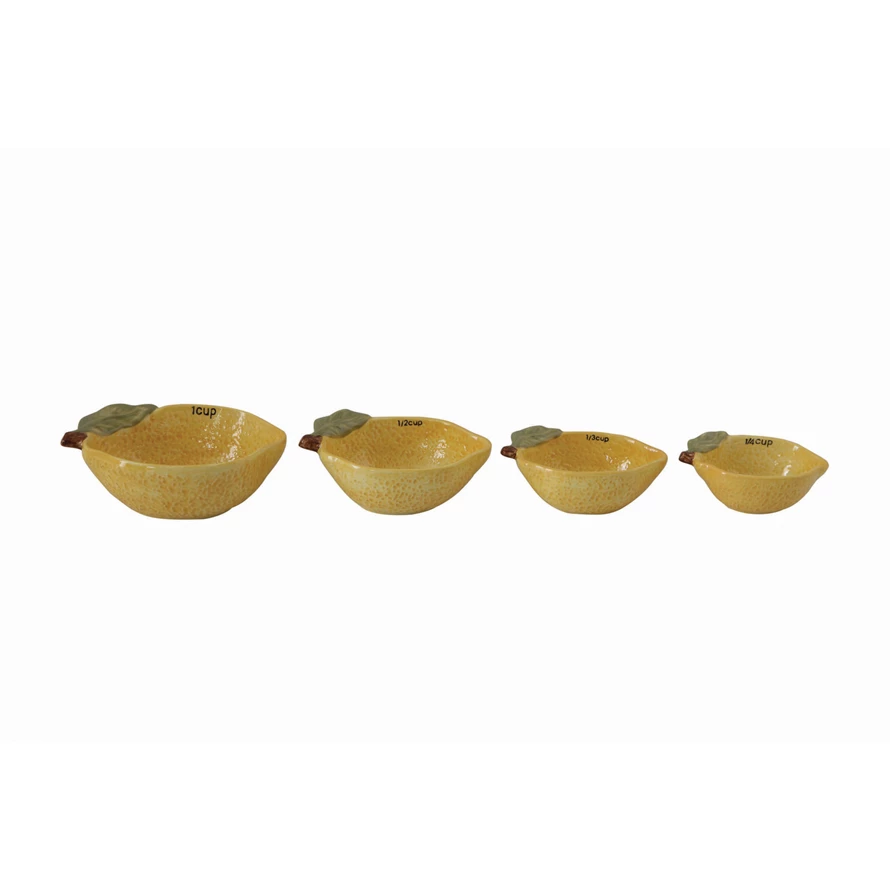 Set of four stoneware lemon-shaped measuring cups with a matte finish.