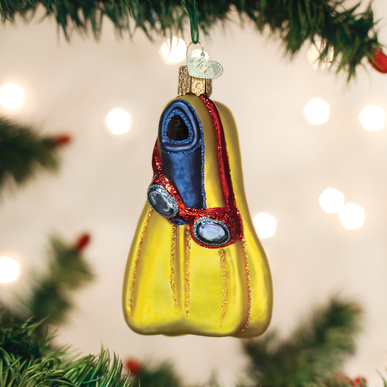 Yellow glass swim flippers ornament with blue goggles hanging on a Christmas tree branch.