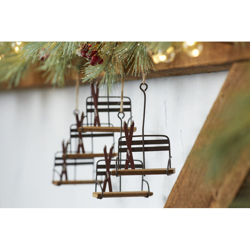 Wooden ski lift chair ornament with metal accents and snow-tipped skis on the seat.