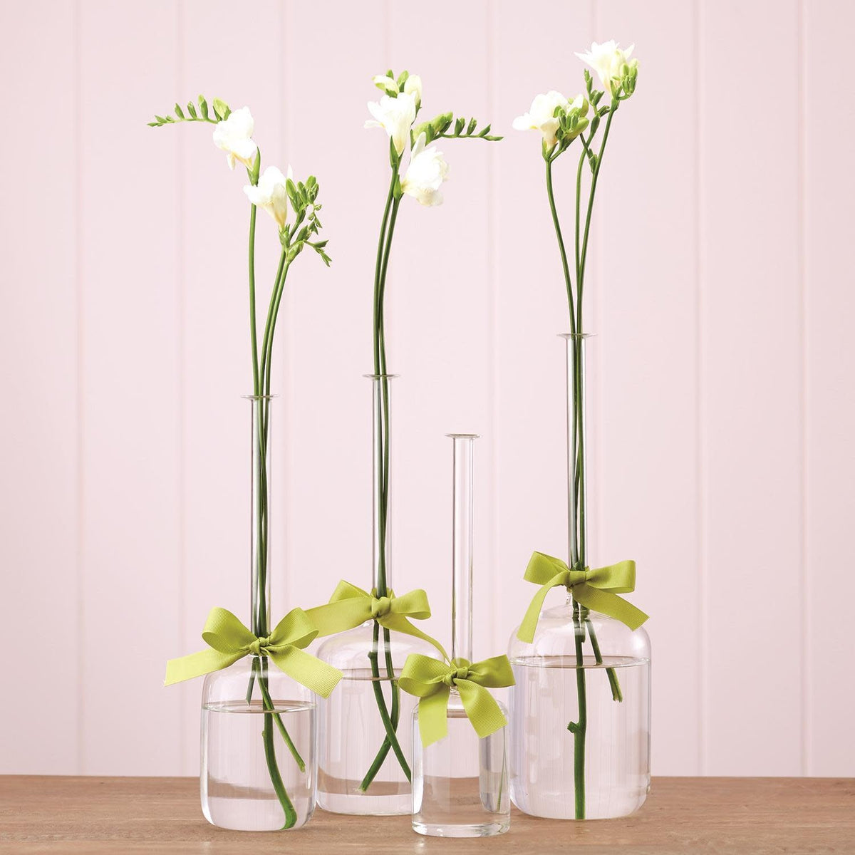 Hand-blown glass jug vase with a sage green ribbon accent around the neck.