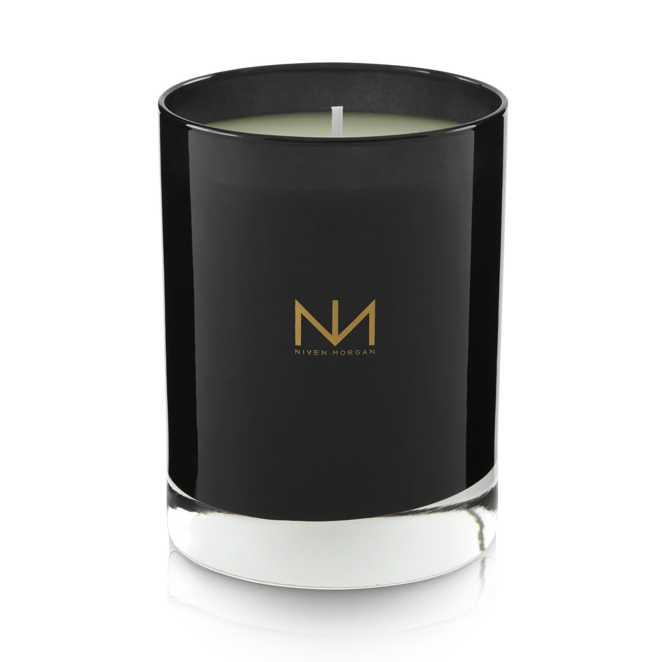 Pepper Sage & Cedar candle in a dark navy glass jar with a gold Niven Morgan logo.