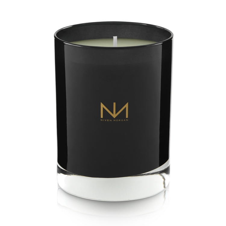 Pepper Sage & Cedar candle in a dark navy glass jar with a gold Niven Morgan logo.