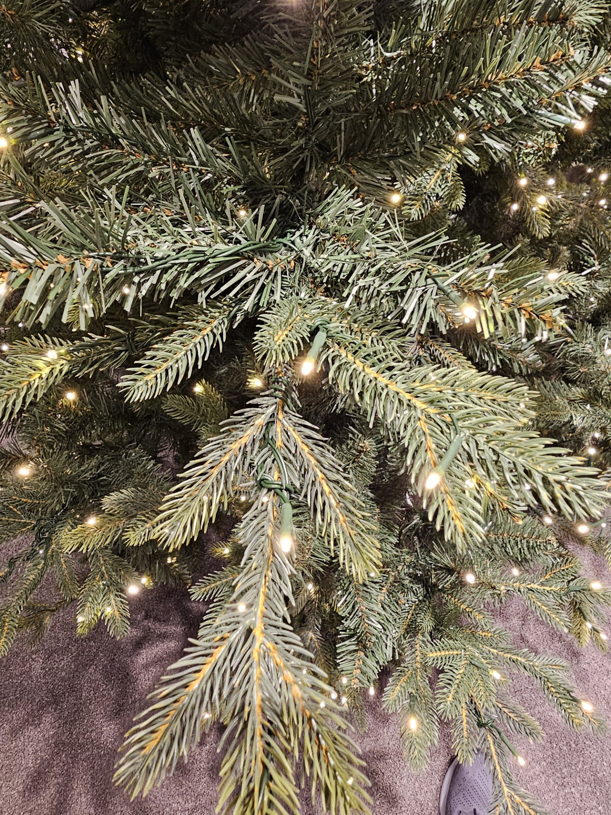 Close-up of a 7.5' Layered Montana Christmas tree with warm white finger light LEDs and green tips.