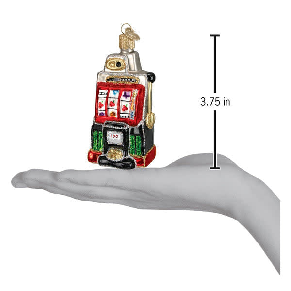 Glass slot machine ornament with silver accents, hand-painted red body, glitter finish, and classic three-reel design.
