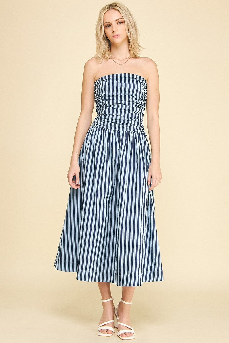 Woman wearing a Diana Stripe Tube Maxi Dress in blue and white vertical stripes with tucked bodice.