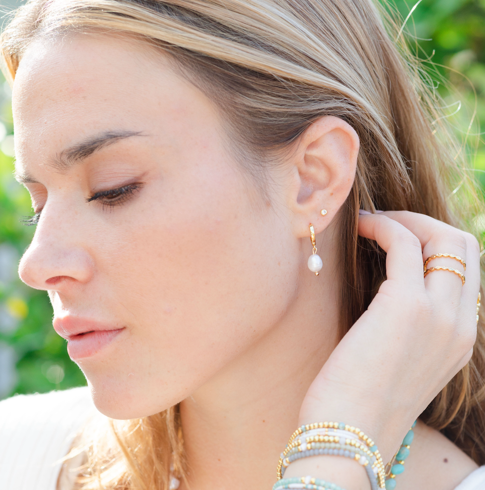 Small pearl drop huggie earrings with an 18k gold plated brass base.