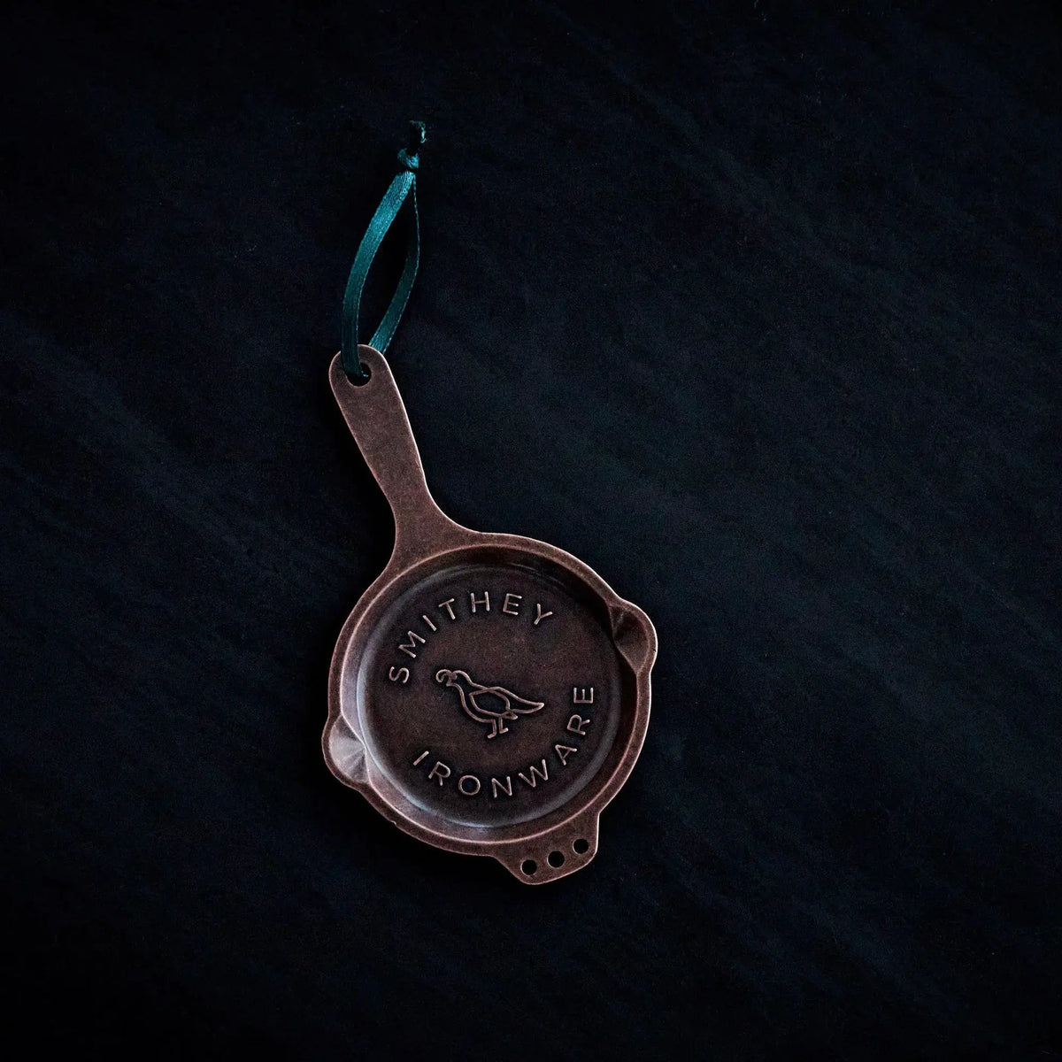 Polished kirksite cast iron skillet ornament with three-hole helper handle and quail logo.