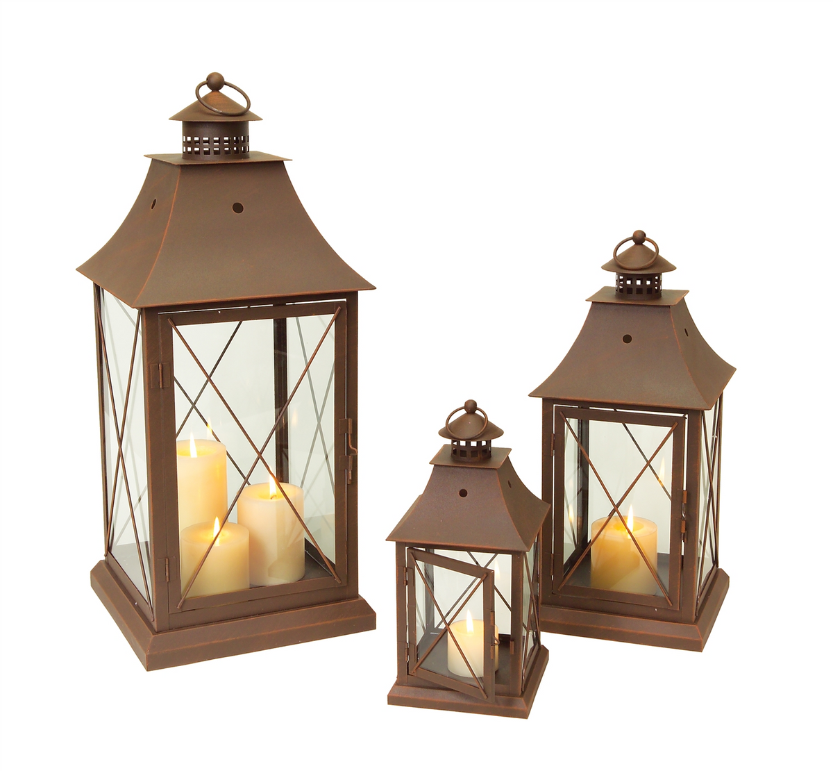 Three rustic brown metal lanterns in small, medium, and large sizes with lit pillar candles inside.