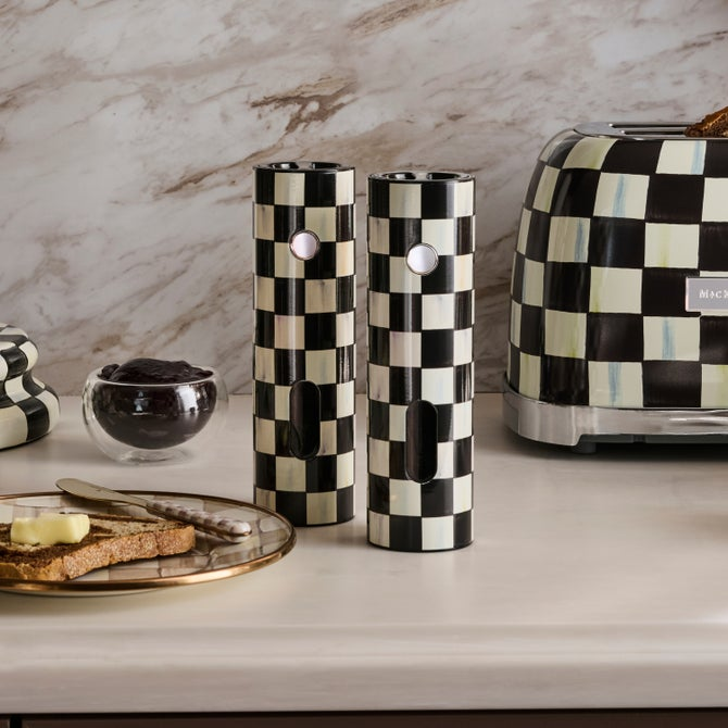 Two Courtly Check electric salt and pepper grinders on a counter next to a matching toaster.